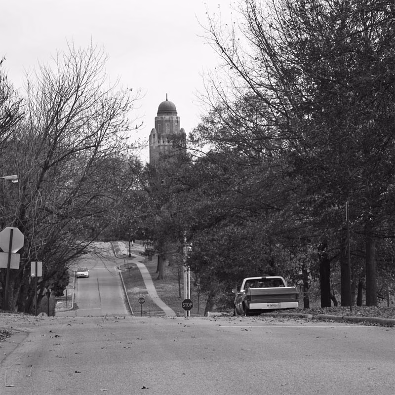 Street view in Shrewsbury, Missouri with stop sign and trees in autumn near a local dispensary